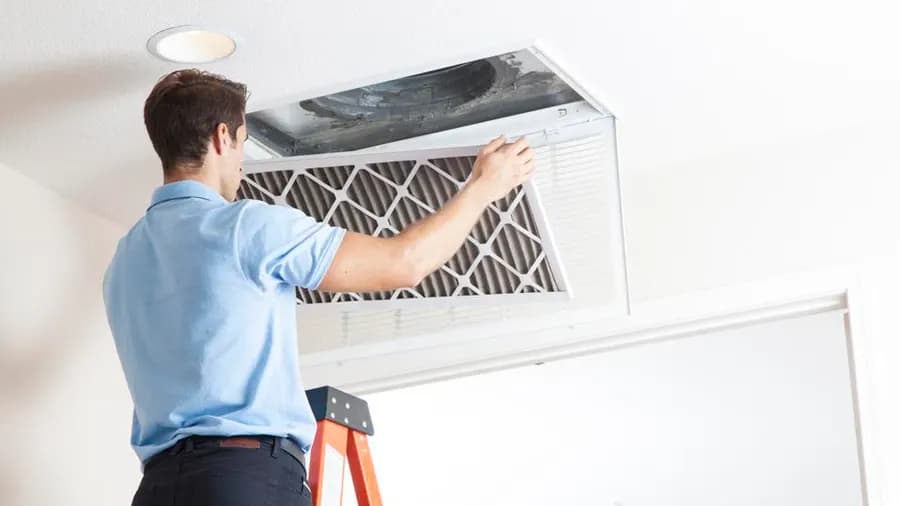 HVAC technician cleaning evaporator coils and air ducts during AC service in Phoenix